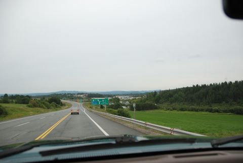 1996 Ford Bronco - View from inside a vehicle on a highway, approaching an exit with green signs.