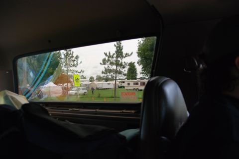 1996 Ford Bronco - Looking out from a vehicle at a field with RVs and tents under an overcast sky.