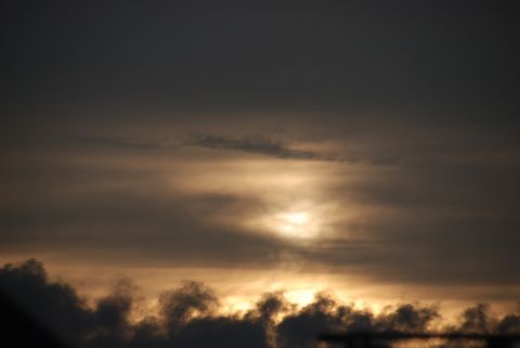 1996 Ford Bronco - The sky is filled with dark, textured clouds as the sun attempts to break through the haze.
