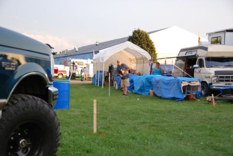 1996 Ford Bronco - 1996 Ford Bronco fender and tire visible in foreground, with campsite and RVs behind.