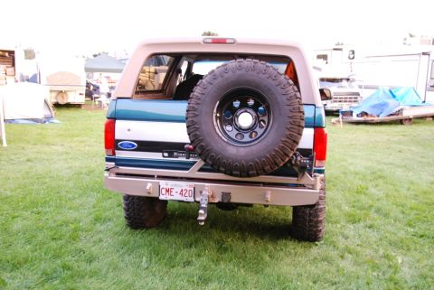 1996 Ford Bronco - This Ford Bronco is parked on grass with tents and trailers in the background.