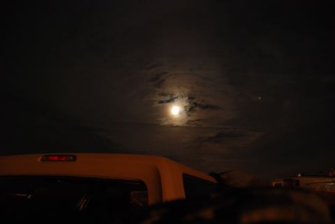 1996 Ford Bronco - A view from inside a vehicle looking towards the rear, under a full moon.