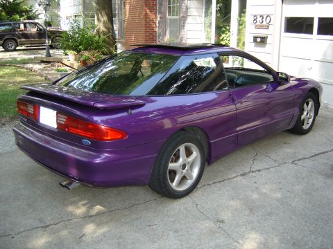 1994 Ford Probe - A purple 1994 Ford Probe is parked in a driveway next to a house and garage.