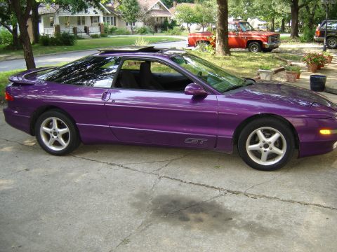 1994 Ford Probe - Purple 1994 Ford Probe GT with sunroof, parked in a residential area with a red pickup truck behind it.
