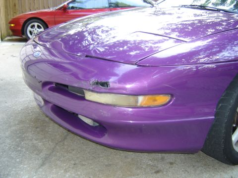 1994 Ford Probe - A purple car's damaged front end is shown, with another red car visible in the background.
