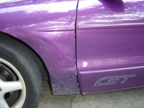 1994 Ford Probe - Close-up of a purple 1994 Ford Probe GT's side, highlighting the door seam and fender detail.