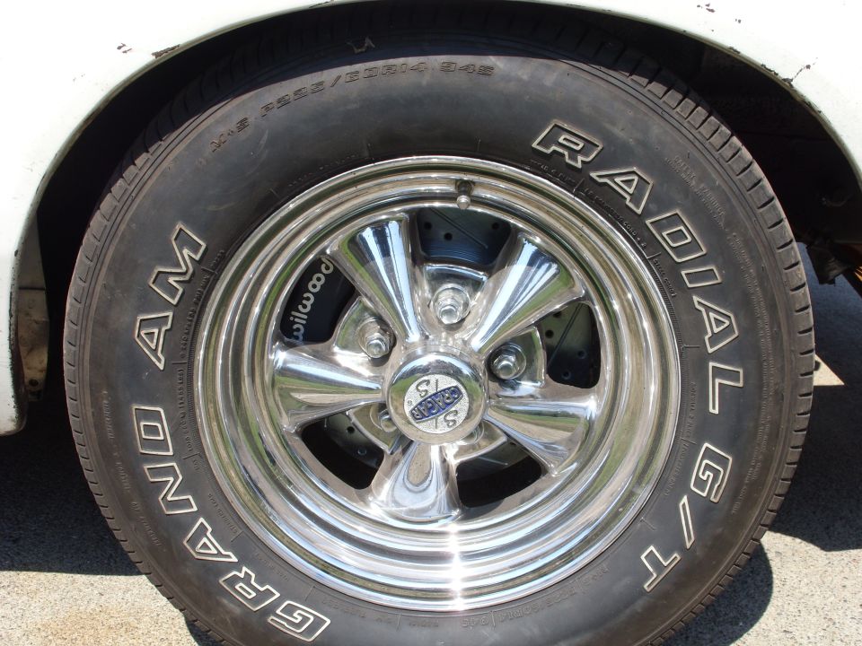 Close-up of a chrome wheel with a Grand Am Radial G/T tire and Wilwood brake caliper