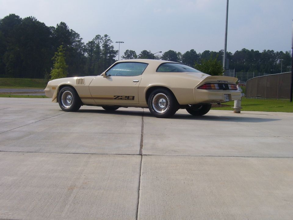Tan Chevrolet Camaro Z28 parked on concrete lot. Z28 badging visible on door