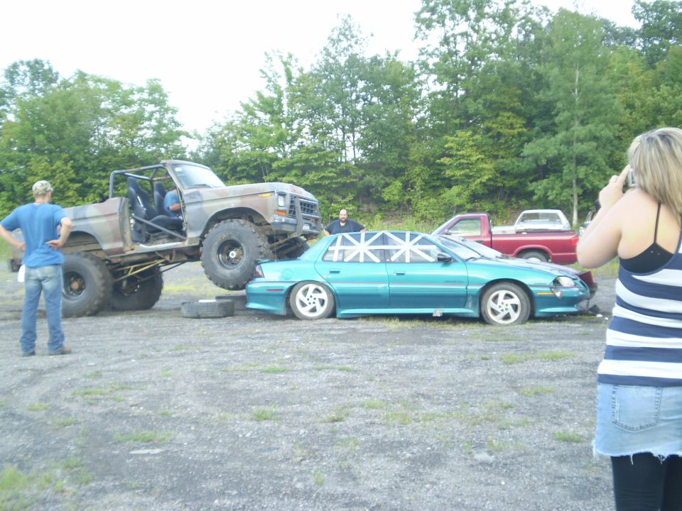 Lifted 1979 Ford Bronco crushing a teal sedan