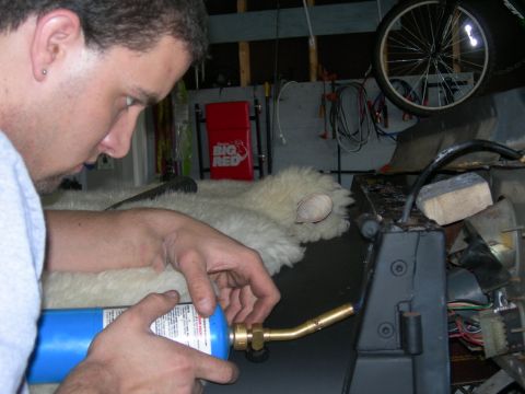 1991 Jeep Wrangler - A man works on the interior of a vehicle, possibly a Jeep Wrangler, with a torch.