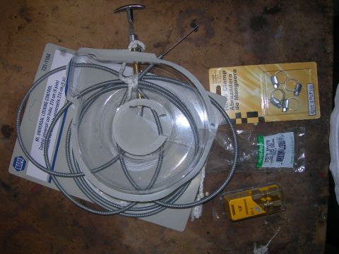 1991 Jeep Wrangler - Various automotive parts and tools are laid out on a wooden surface, including a NAPA cable and hose clamps.