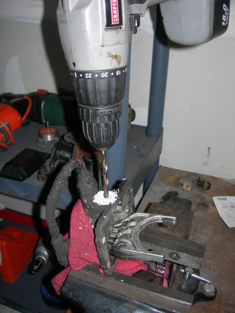 1991 Jeep Wrangler - A drill bit is shown drilling into a metal component secured in a vise, with a red cloth underneath.
