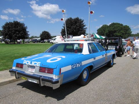 1991 Ford LTD Crown Victoria - Rear view of a blue and white 1970s Pontiac POLICE sedan numbered 2976 with roof beacons at an outdoor show.