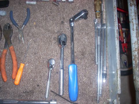1992 Ford Bronco - A collection of various hand tools, including ratchets, pliers, and wrenches, laid out on a carpeted surface.