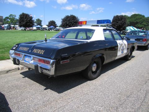 1991 Ford LTD Crown Victoria - Rear view of a black and white 1970s Mercury highway patrol sedan lettered HIGHWAY PATROL with roof lightbar.