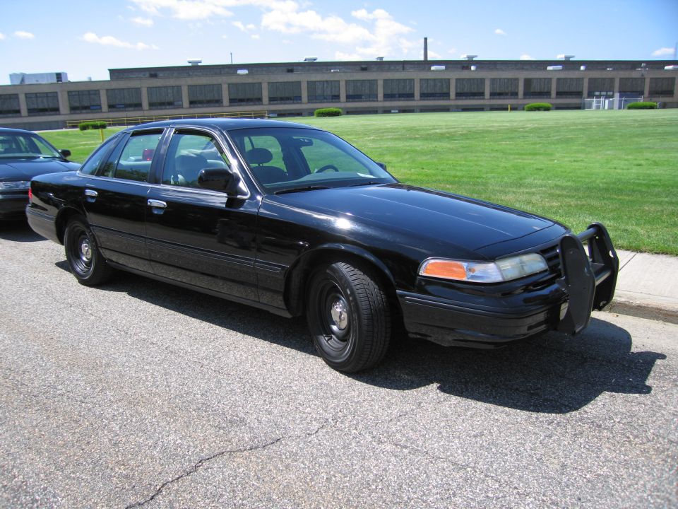All-black Ford Crown Victoria sedan with push bar and steel wheels