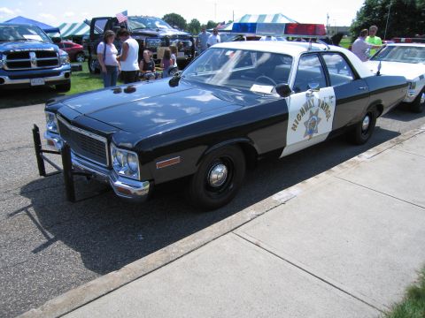 1991 Ford LTD Crown Victoria - Front three-quarter view of a black-and-white Highway Patrol sedan with a push bar and roof lights at a crowded outdoor show.