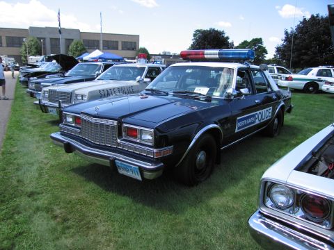 1991 Ford LTD Crown Victoria - black-and-white North Haven Police sedan with roof light bar parked in a row of police cruisers on grass at a show.