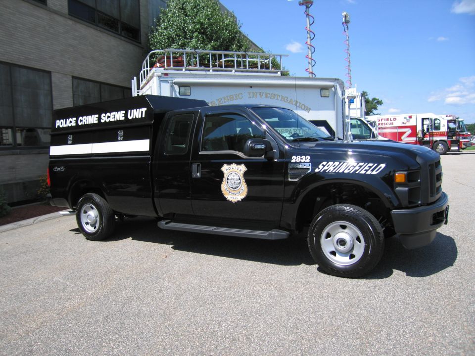 Black Ford F-250 'Police Crime Scene Unit' pickup with Springfield markings parked by trucks
