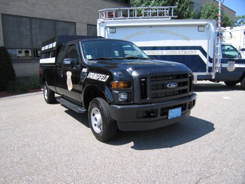 1991 Ford LTD Crown Victoria - Front three-quarter view of a black Ford F-250 Super Duty Springfield police pickup, unit 2632, on pavement by an investigation truck.