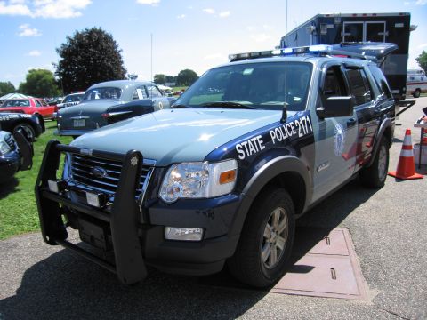 1991 Ford LTD Crown Victoria - Massachusetts State Police Ford Explorer SUV, unit 2171, with a heavy front push bar parked beside a command truck.