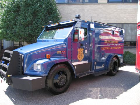 1991 Ford LTD Crown Victoria - blue Springfield Police Department 'Tactical Operations' armored truck, unit 130, with a heavy front bumper parked in a lot.