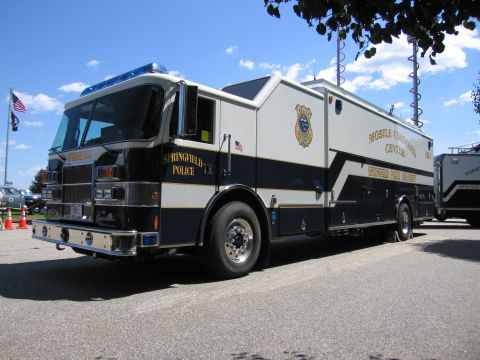 1991 Ford LTD Crown Victoria - black Springfield Police mobile command center truck on a fire-apparatus chassis parked on pavement under a blue sky.