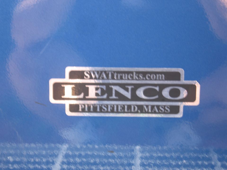 Lenco SWATtrucks.com badge plate reading Pittsfield, Mass on a blue tarp