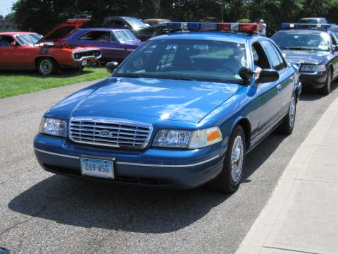 1991 Ford LTD Crown Victoria - blue Ford Crown Victoria police car viewed from the front with a roof light bar, others parked behind it.