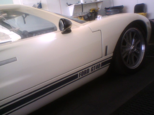 White Ford GT40 coupe side detail with blue rocker stripes, stalk mirror and alloy wheel