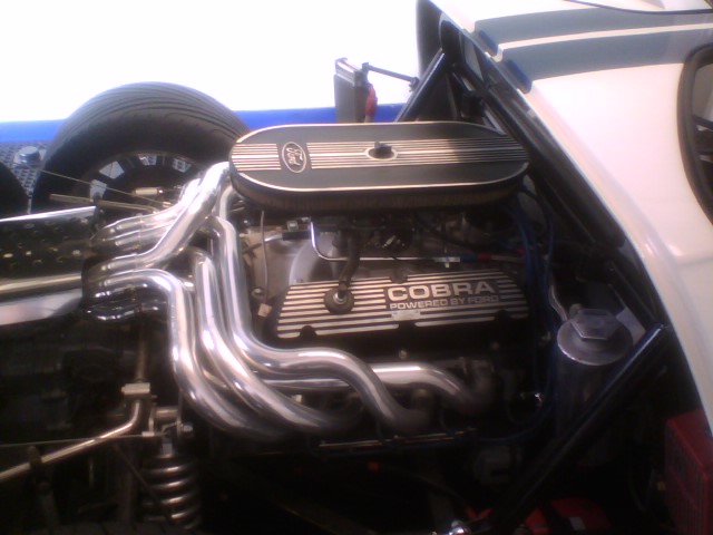 Ford V8 with Cobra finned valve covers and polished headers in a white roadster