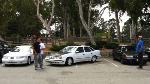 2003 Ford Taurus - Multiple sedans are parked in an outdoor lot with trees in the background.