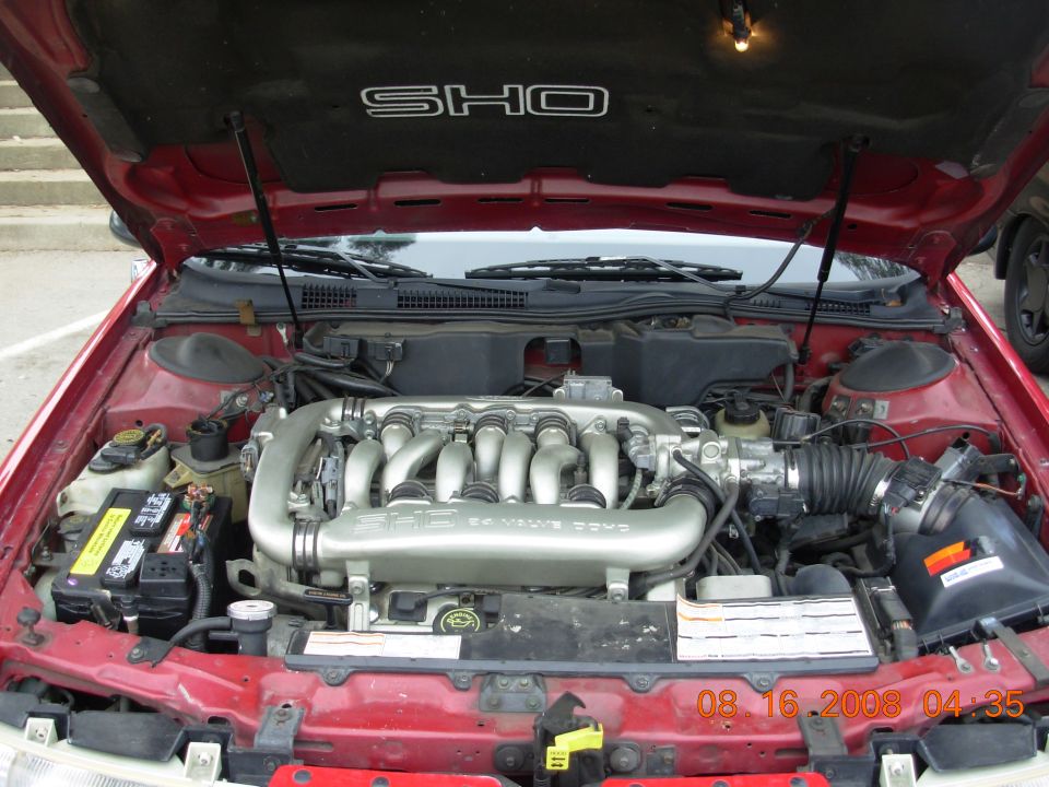 1995 Ford Taurus SHO engine bay with hood open. V8 engine with silver intake manifold