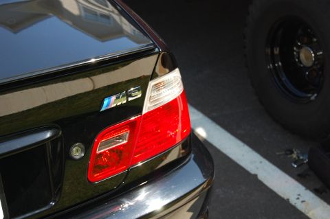 2002 BMW M3 - The rear of a black BMW M3 is shown, its distinctive M3 badging and taillights.