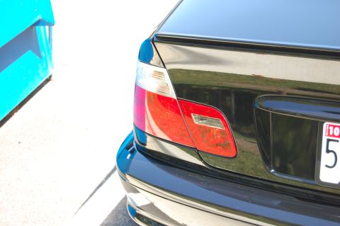 2002 BMW M3 - Close-up of a black car's rear tail light assembly, showing red and clear light components.