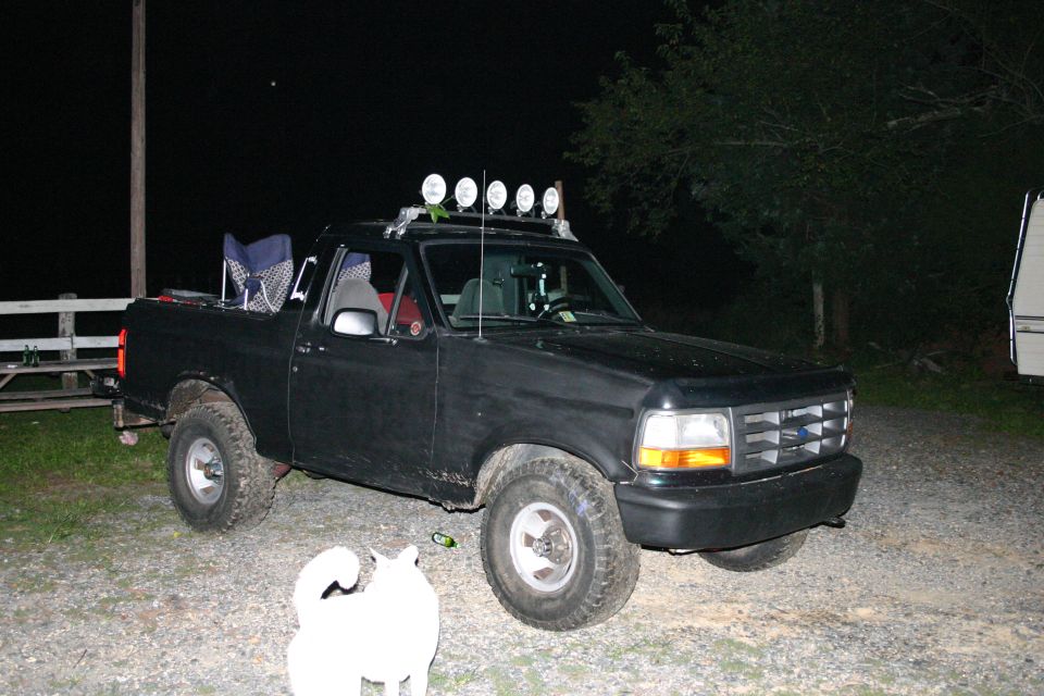 Black 1995 Ford F-150 pickup truck, 3q-front view, with roof-mounted off-road lights