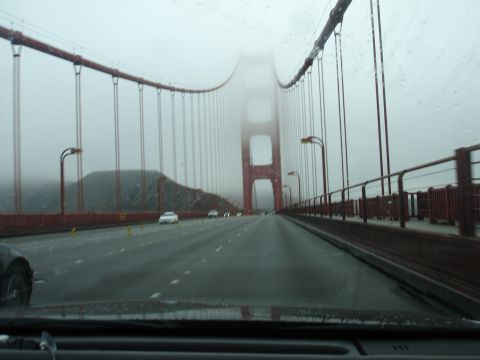 1990 Ford Taurus - Driving across the Golden Gate Bridge on a foggy day, with other vehicles visible on the roadway.