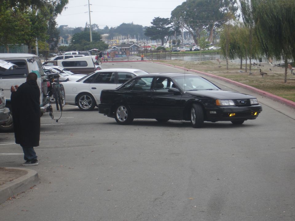 Black sedan with yellow fog lights, seen from a 3/4 front angle