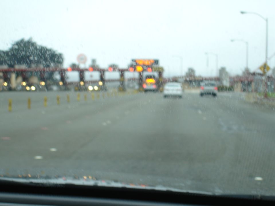 Toll plaza with multiple cars driving through in rainy weather