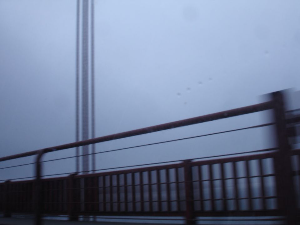 Bridge railing and tower visible through fog