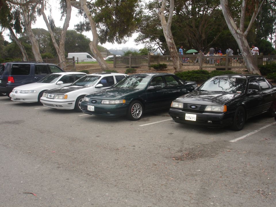 Dark green sedan parked in a lot, front quarter view. License plate visible