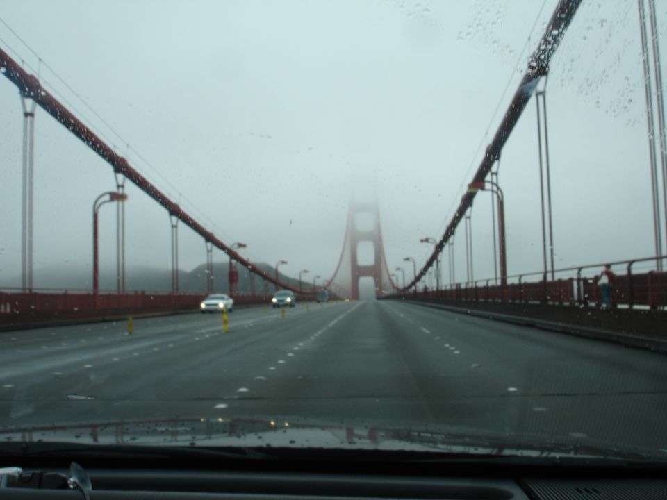Golden Gate Bridge on a foggy day with cars on the road
