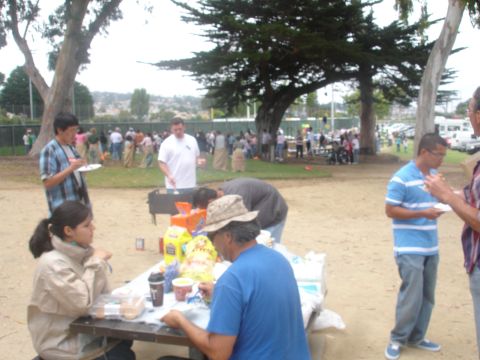 1990 Ford Taurus - An outdoor park event with people participating in sack races and enjoying food.