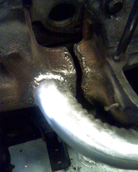 1953 Ford Mainline - Close-up of the exhaust manifold and pipe on a 1953 Ford Mainline engine.