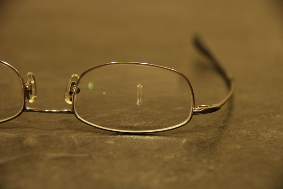 Close-up of eyeglasses with a small object stuck to the lens
