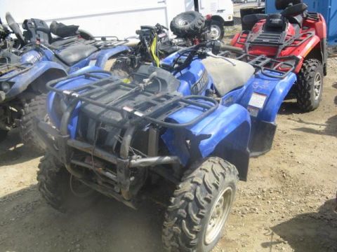 2003 Yamaha GRIZZLY 660 - Multiple ATVs are parked outdoors on a dirt lot, with one blue ATV in the foreground.