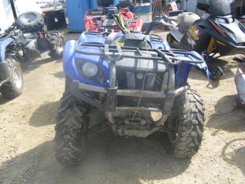 2003 Yamaha GRIZZLY 660 - A blue ATV is parked in an outdoor lot with other vehicles visible in the background.