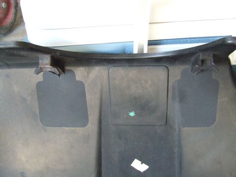 2003 Ford Crown Victoria - This is a close-up of the underside of a black plastic panel, likely from a vehicle's undercarriage. It features two square cutouts and two…