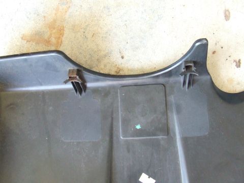 2003 Ford Crown Victoria - This is a close-up shot of the underside of a black plastic car part, possibly a splash shield or undertray, showing two metal clips attach…
