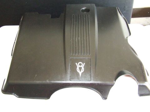 2003 Ford Crown Victoria - A black V8 engine cover is shown from a high angle, resting on a white surface with a dark background.